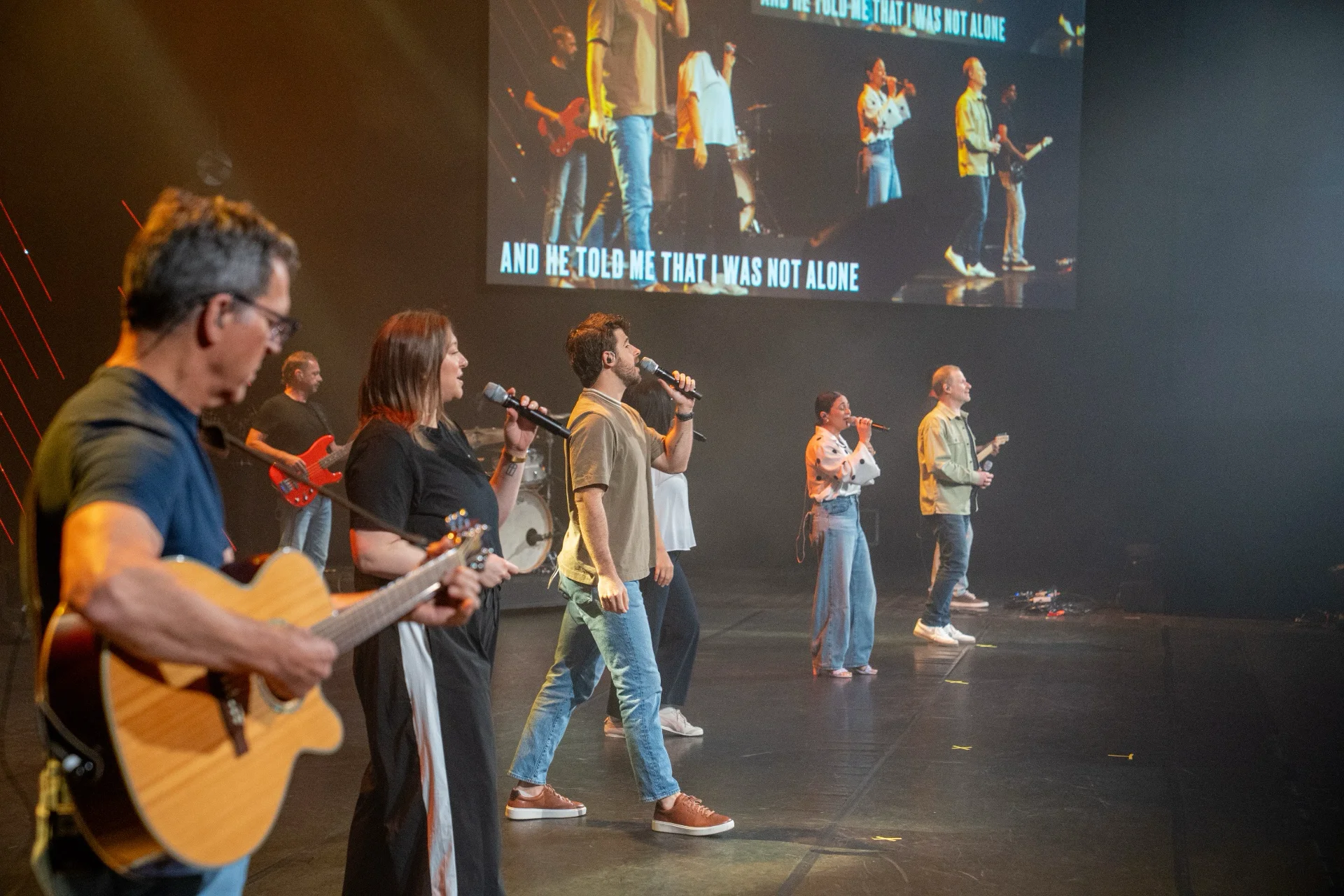 Worship team singing on stage during a Sunday Experience.