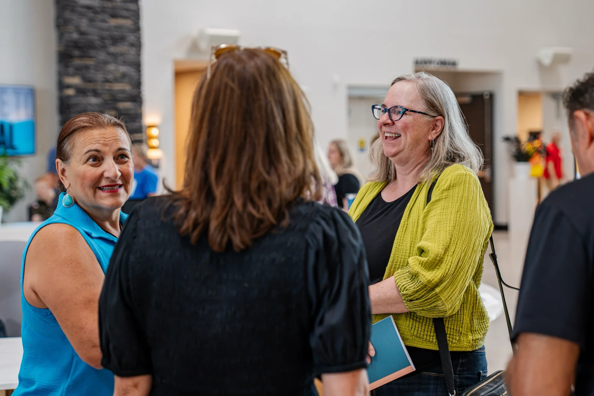 Two women laughing together in conversation in the Central lobby.