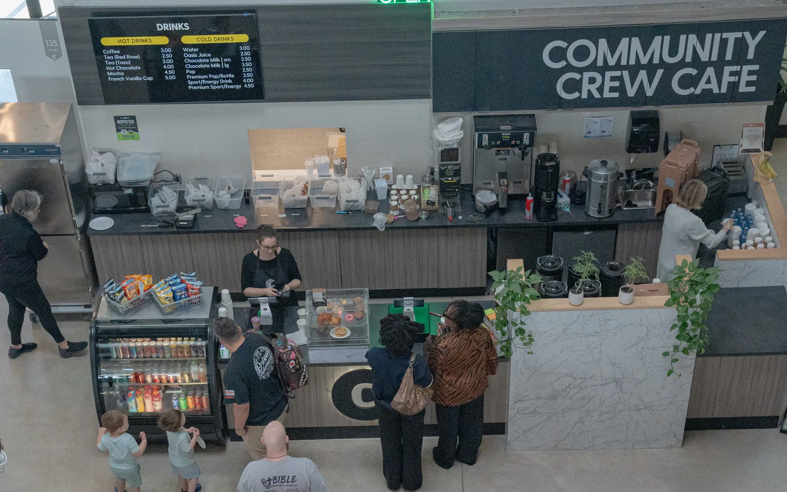 The Community Crew Cafe team serving guests at the counter on a Sunday morning.