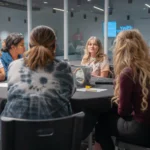 Parents in conversation around a round table during a group discussion.